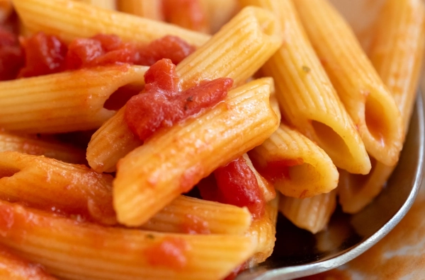 Крупний план приготованих пенне в червоному соусі
