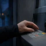 Рука прикриває клавіатуру банкомата під час введення PIN-коду — захист від скімінгу
