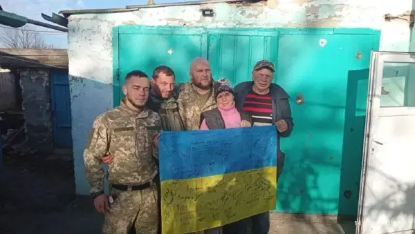 Українські військові піднімають український прапор у звільненому населеному пункті на Херсонщині, люди зустрічають їх з квітами