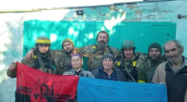 Українські військові піднімають український прапор у звільненому населеному пункті на Херсонщині, люди зустрічають їх з квітами